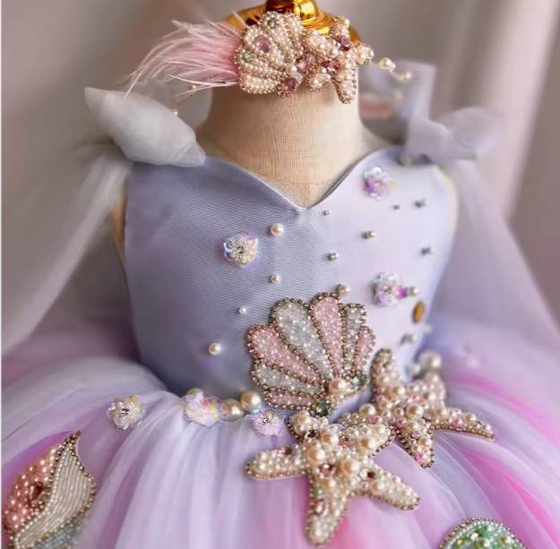 Decorative dress with shell and starfish embellishments on a mannequin.