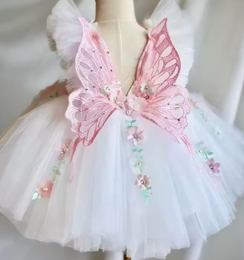 White dress with pink butterfly wings on a mannequin against a neutral background