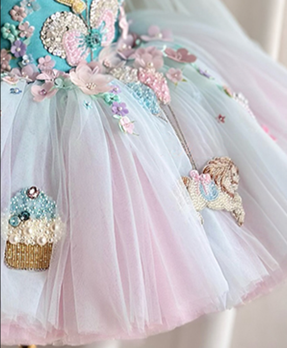 Pastel-colored dress with floral and cupcake decorations on a white background
