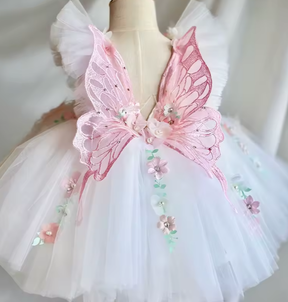 White dress with pink butterfly wings on a mannequin against a neutral background