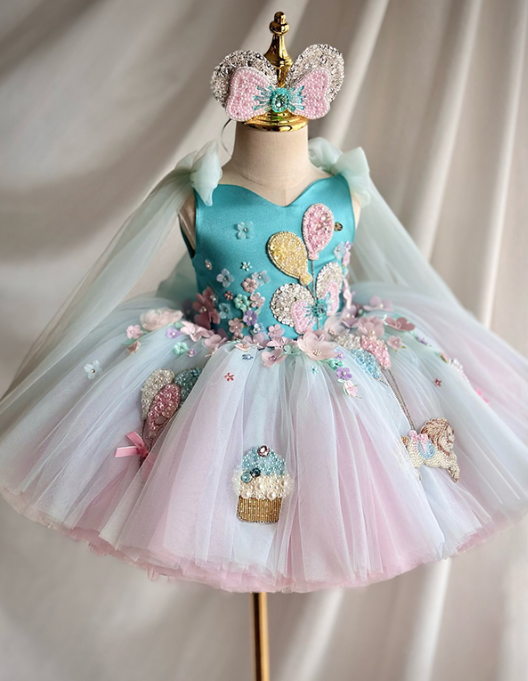 Children's dress with floral details and a crown on a mannequin against a plain background