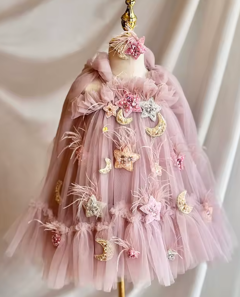 Pink tulle dress with decorative elements on a mannequin against a plain background