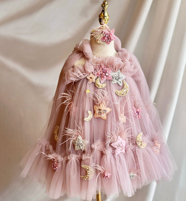 Pink tulle dress with decorative elements on a mannequin against a plain background
