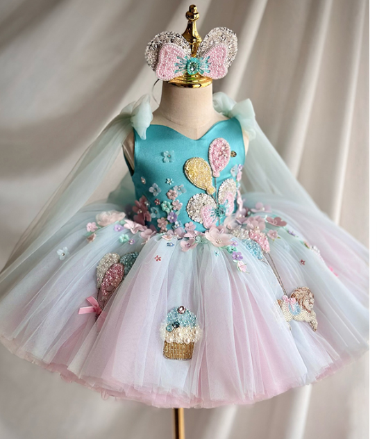 Colorful children's dress with floral embellishments on a mannequin against a plain background